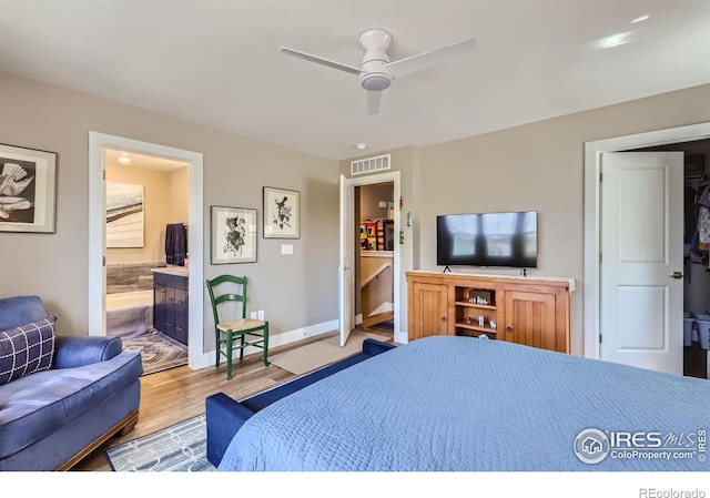 bedroom featuring ensuite bath, light hardwood / wood-style floors, and ceiling fan