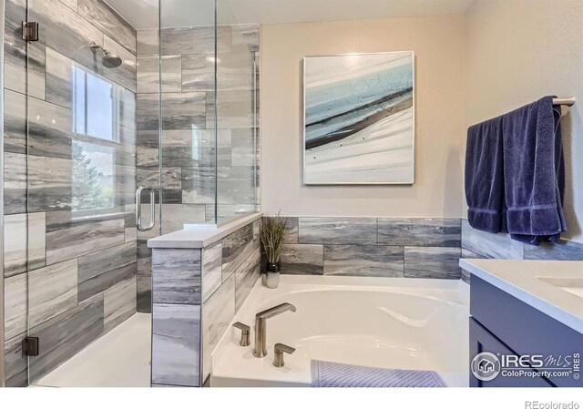 bathroom with vanity and separate shower and tub