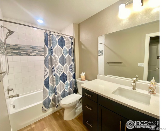 full bathroom featuring vanity, hardwood / wood-style flooring, shower / bath combination with curtain, and toilet