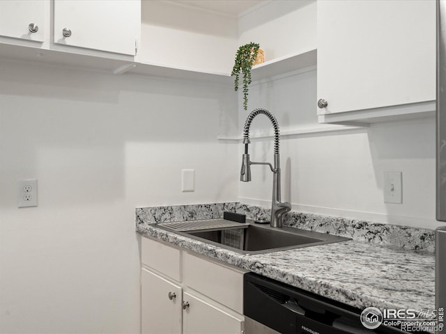 kitchen with white cabinetry, black dishwasher, and sink