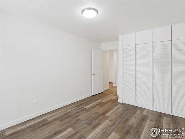 unfurnished bedroom with hardwood / wood-style floors and a closet