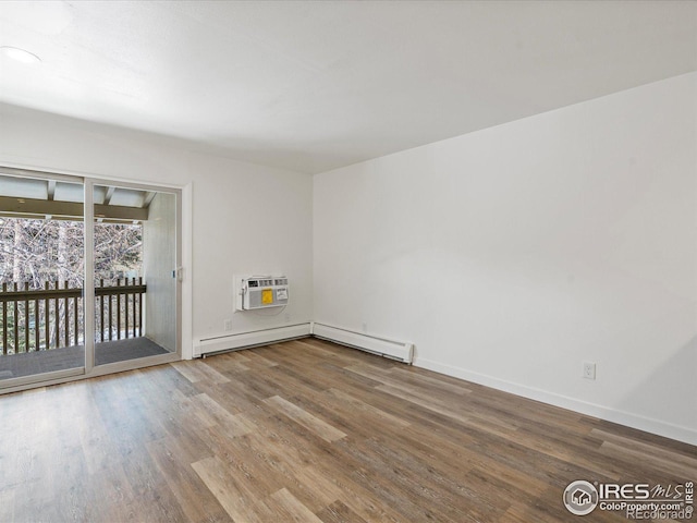 spare room featuring hardwood / wood-style flooring, a baseboard heating unit, and a wall mounted air conditioner