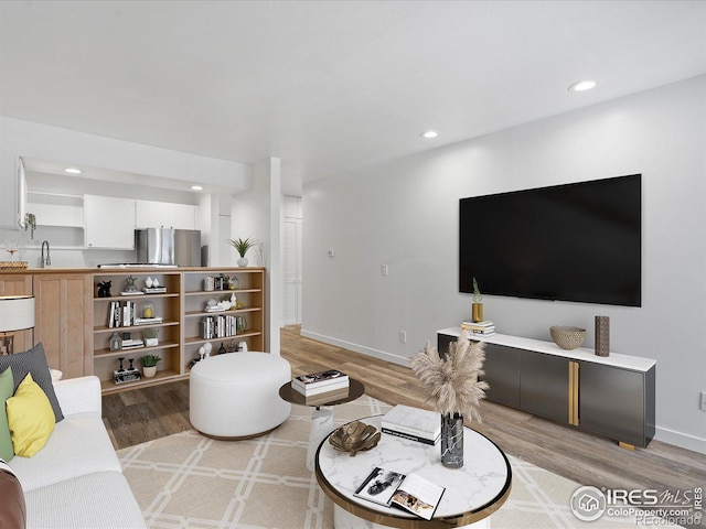 living room featuring hardwood / wood-style flooring and sink