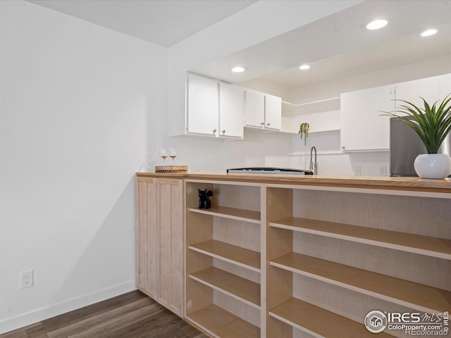 kitchen with dark hardwood / wood-style floors and white cabinets