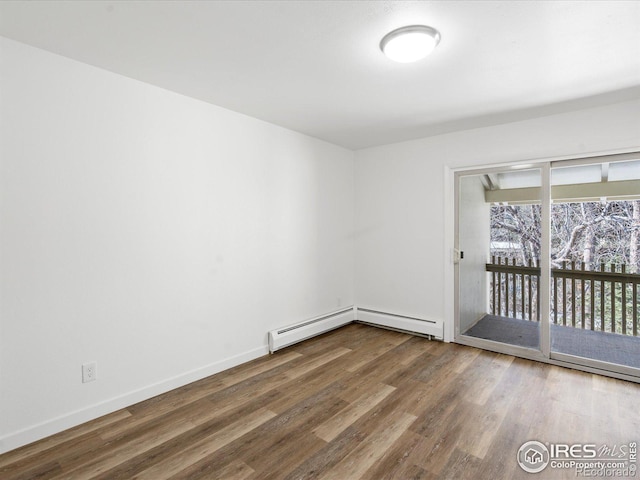 spare room with hardwood / wood-style flooring and a baseboard radiator