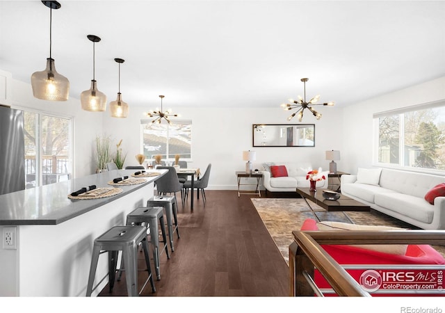 living room featuring dark wood-type flooring and a notable chandelier