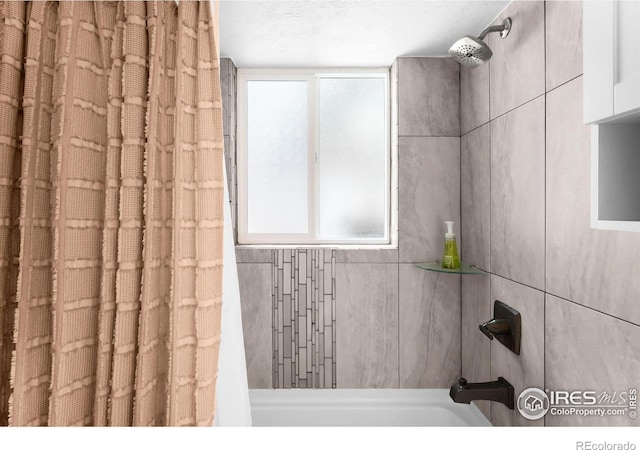 bathroom featuring shower / tub combo with curtain and a textured ceiling