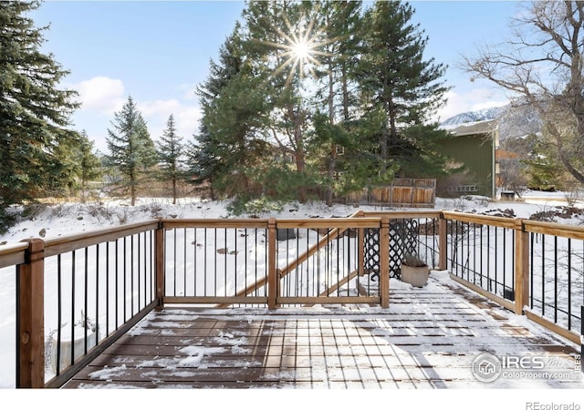 snow covered deck featuring a mountain view