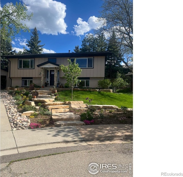 raised ranch featuring a front lawn