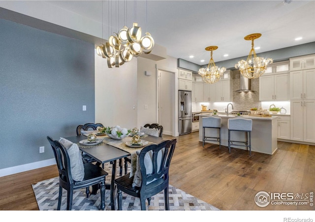 dining room featuring an inviting chandelier, dark hardwood / wood-style floors, and sink