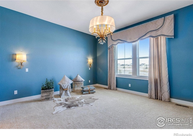 unfurnished room featuring a notable chandelier and carpet