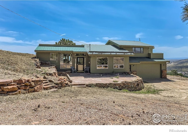 view of front of property with a garage and a patio