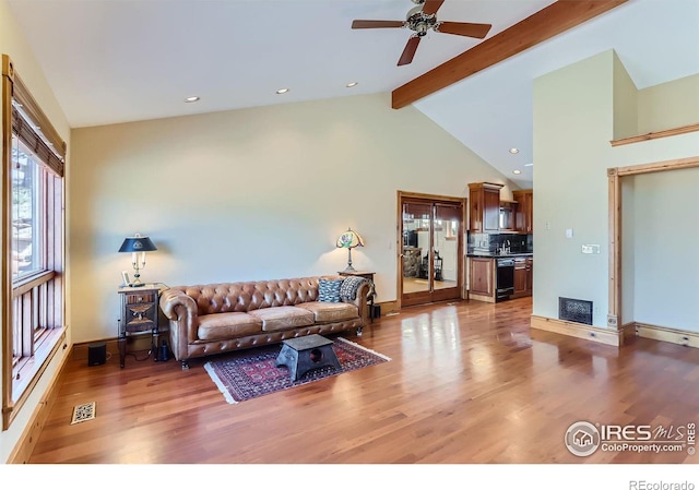 living room with beam ceiling, wood-type flooring, high vaulted ceiling, and ceiling fan