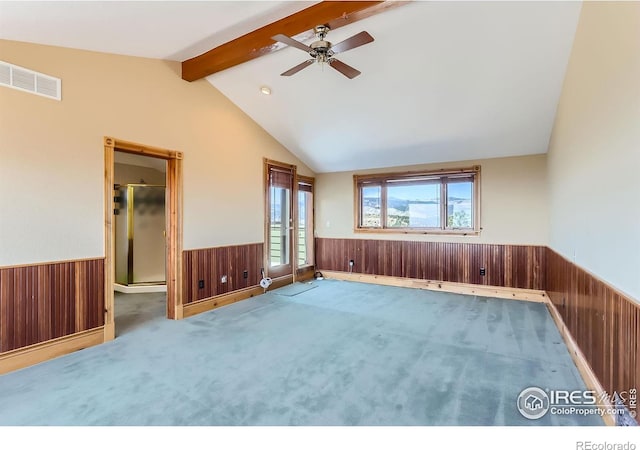 unfurnished room featuring ceiling fan, wooden walls, carpet, and vaulted ceiling with beams