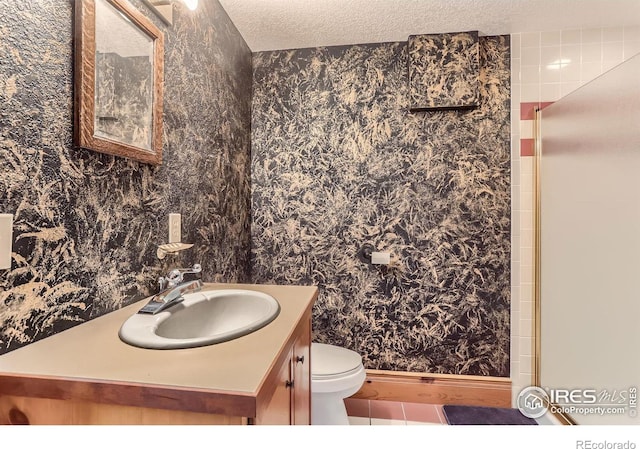 bathroom with tile patterned flooring, vanity, a textured ceiling, a shower with shower door, and toilet