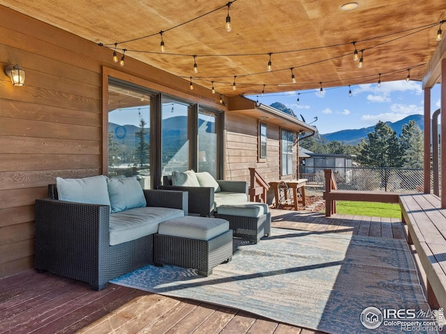 wooden terrace featuring a mountain view and an outdoor hangout area