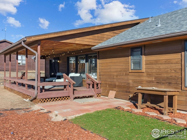 rear view of property featuring an outdoor living space and a deck