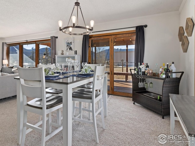 carpeted dining space with a notable chandelier, a mountain view, ornamental molding, and a textured ceiling