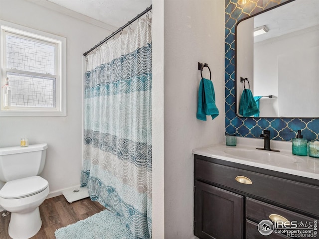 bathroom with crown molding, hardwood / wood-style flooring, vanity, curtained shower, and toilet