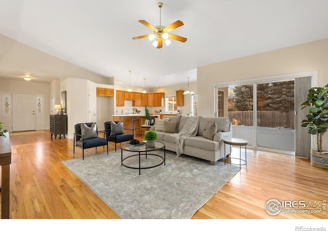 living room with vaulted ceiling, light hardwood / wood-style floors, and ceiling fan