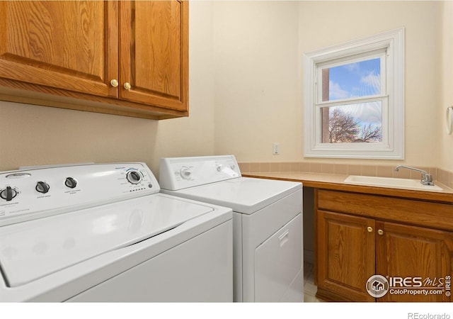 laundry area with cabinets, sink, and washer and clothes dryer