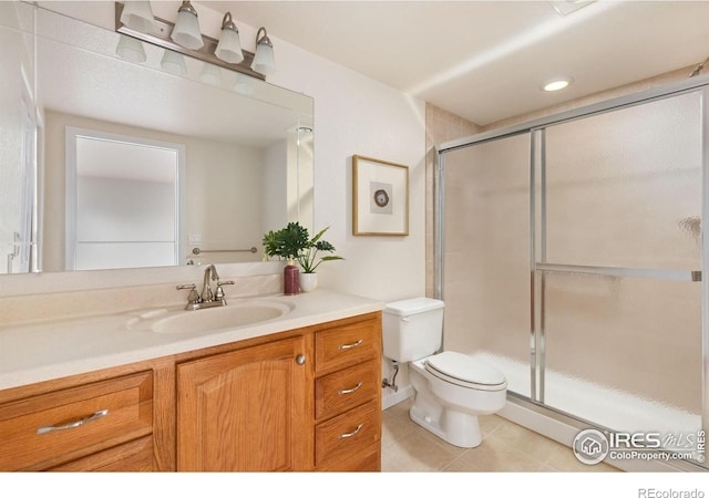 bathroom with walk in shower, vanity, toilet, and tile patterned flooring