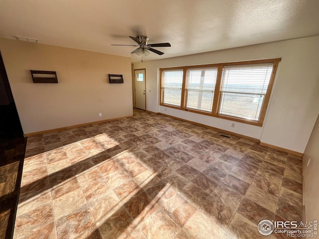 empty room featuring a textured ceiling and ceiling fan