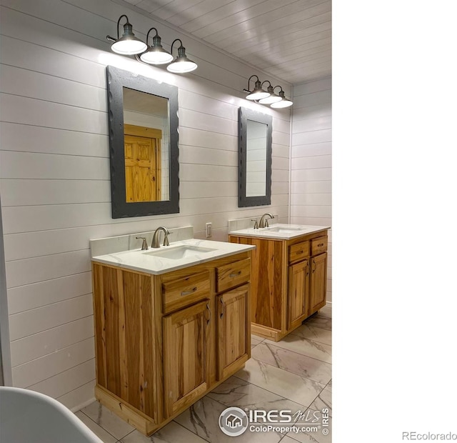 bathroom featuring vanity and wood walls