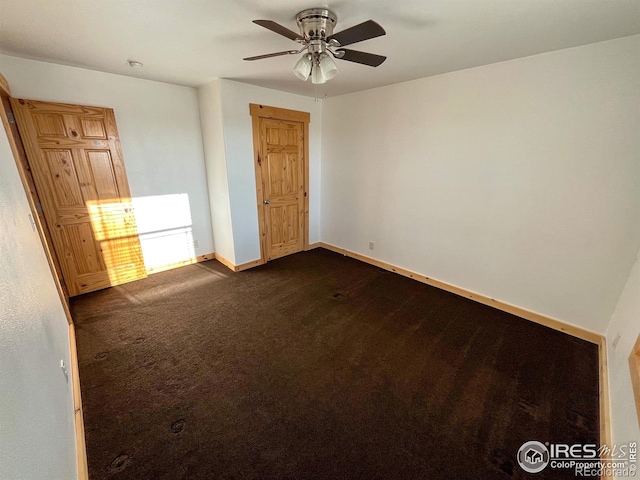 unfurnished room featuring dark carpet and ceiling fan