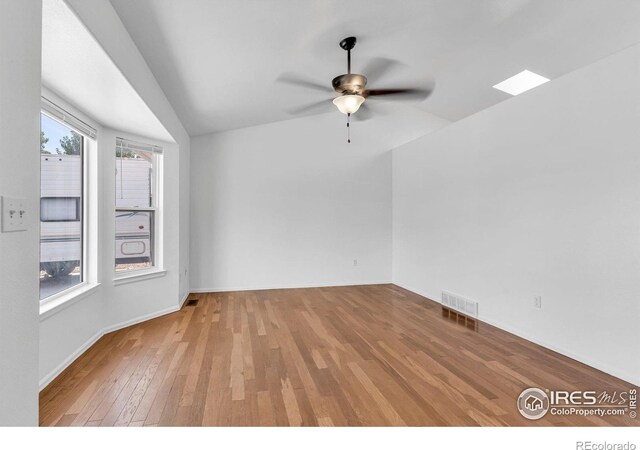 spare room featuring lofted ceiling, light hardwood / wood-style flooring, and ceiling fan