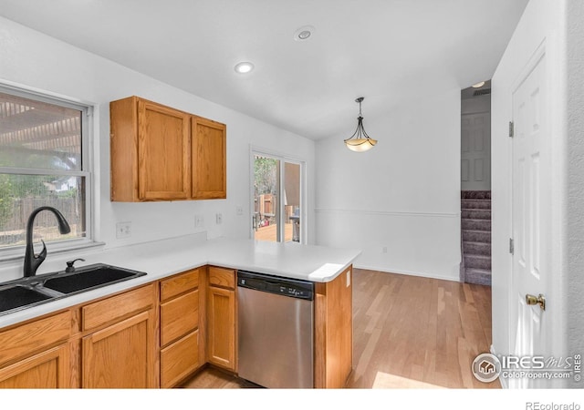 kitchen featuring decorative light fixtures, sink, stainless steel dishwasher, kitchen peninsula, and light hardwood / wood-style flooring