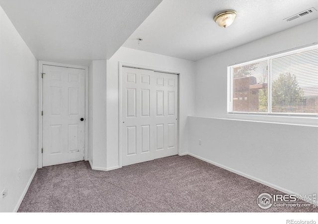 unfurnished bedroom featuring a closet and carpet flooring