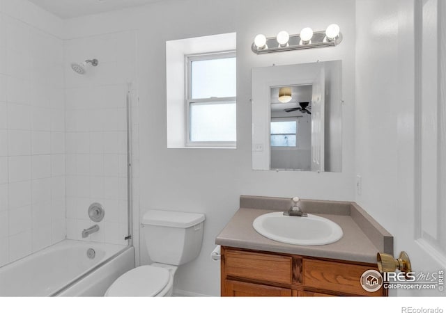 full bathroom with tiled shower / bath, vanity, and toilet