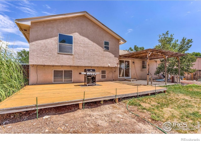 rear view of house with a pergola and a deck