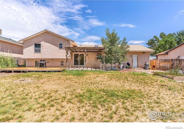 back of property with a yard, a deck, and a pergola