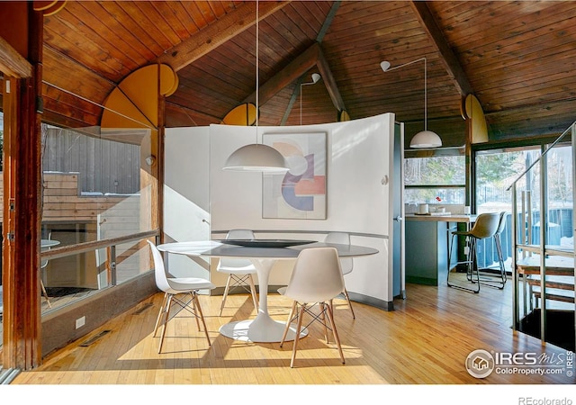 dining room featuring lofted ceiling with beams, hardwood / wood-style floors, and wooden ceiling