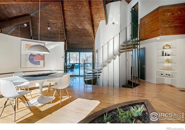 dining space with high vaulted ceiling, wood ceiling, light hardwood / wood-style floors, and beamed ceiling