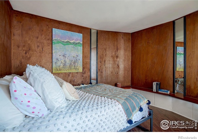 bedroom featuring wooden walls