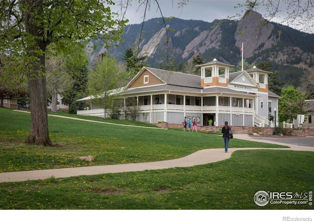 view of front of house with a mountain view and a front yard