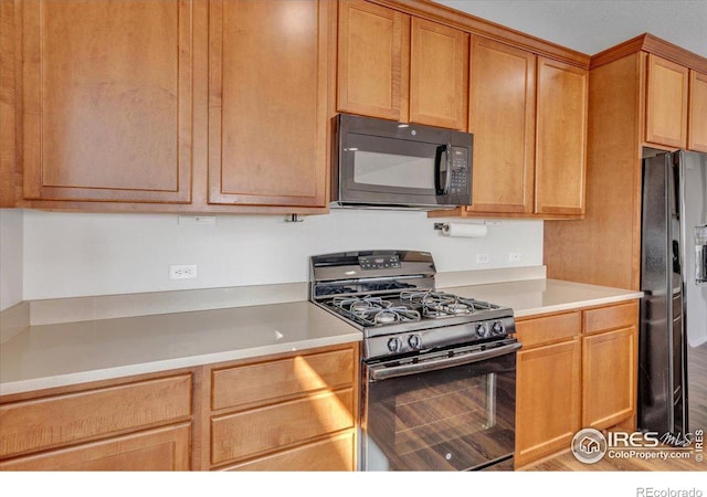 6508 Copper Dr, Frederick, CO 80516 - kitchen with black appliances, light countertops, and wood finished floors