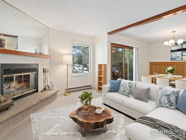 living room with an inviting chandelier, a baseboard heating unit, a textured ceiling, and carpet