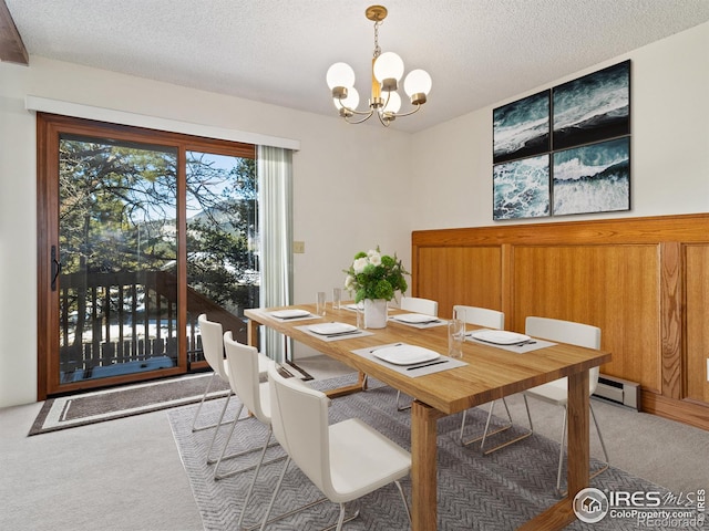 carpeted dining room featuring a textured ceiling and an inviting chandelier