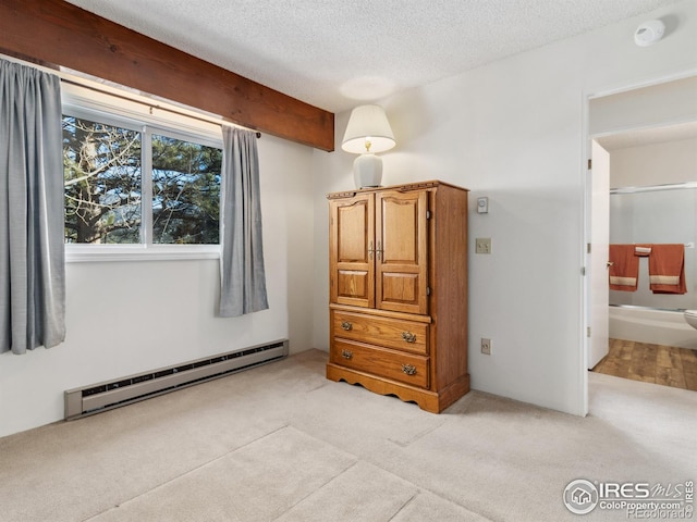 unfurnished bedroom with connected bathroom, a textured ceiling, light carpet, beamed ceiling, and a baseboard heating unit