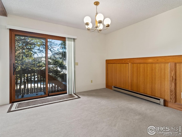 carpeted spare room with a textured ceiling, a notable chandelier, and baseboard heating