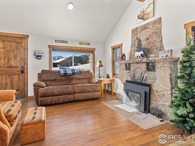 living room with a fireplace, hardwood / wood-style flooring, and vaulted ceiling