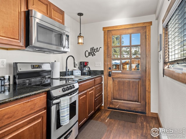 kitchen featuring a healthy amount of sunlight, appliances with stainless steel finishes, sink, and decorative light fixtures