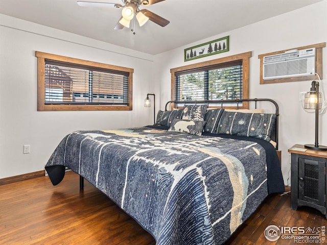 bedroom featuring ceiling fan, dark hardwood / wood-style flooring, and a wall unit AC