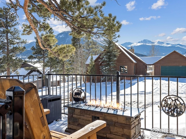 snow covered deck with a mountain view and grilling area