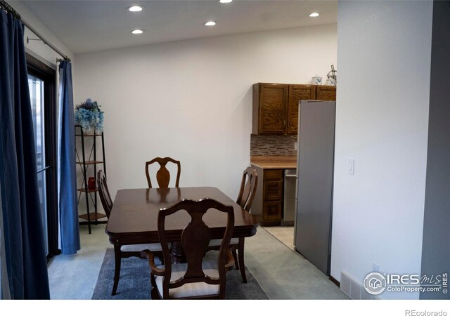 dining space featuring light colored carpet