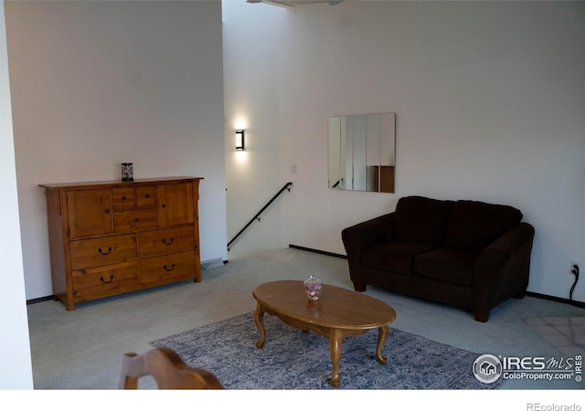 carpeted living room with a towering ceiling